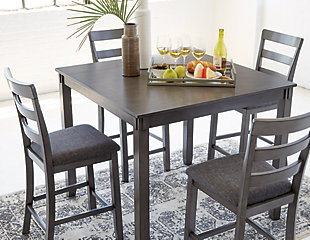 It’s so easy being gray—at least the Bridson 5-piece dining set makes it seem that way. This transitional counter-height table and barstool ensemble sports a charcoal gray finish with textured gray upholstery for an on-trend and relevant appeal. Plushly upholstered seat cushion in a practical polyfiber makes it a pleasure to linger at the table. Best of all, square table design is ideally suited for small spaces.Includes counter height table and 4 barstools | Made of wood, veneer and engineered wood | Medium charcoal gray finish | Ladderback barstools | Cushioned seats covered in textured gray polyester upholstery | Table with tapered leg design | Assembly required | Estimated Assembly Time: 90 Minutes