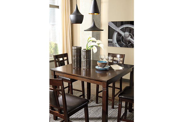 Set the scene for cool, comfortable and ultra-contemporary style with the Bennox counter table set. Counter-height design makes eating in feel more like dining out at a trendy pub. Richly upholstered in a practical faux leather with welcome back supports, the four bar stools are sure to satisfy.Includes counter height table and 4 upholstered barstools | Table made of veneers, wood and engineered wood | Wood frame barstools | Cushioned backs and seats with vinyl upholstery | Assembly required | Excluded from promotional discounts and coupons | Estimated Assembly Time: 60 Minutes