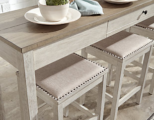 The Skempton counter height table and bar stool set invites you to raise the bar on small space living. An inspired choice for coastal chic or modern farmhouse settings, this clean-lined, simply striking set doubles the charm with brown tone plank effect tops, paired with grayish white bases with rub through effect for timeworn appeal. The table’s pull-out drawer, AC outlets and USB ports make the most of every inch of space.Includes counter height table and 3 bar stools | Made of wood, acacia veneer and engineered wood | Distressed grayish white finish | Cushioned seat with polyester upholstery | Single smooth-gliding drawer | Includes 2 USB ports and AC power outlet; UL Listed | Assembly required | Estimated Assembly Time: 60 Minutes