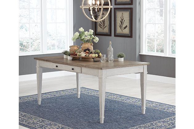 Set the scene for coastal chic or modern farmhouse living with the Skempton dining room table. Clean-lined, simply striking table doubles the charm with a brown tone top with plank effect, paired with a grayish white base with rub through effect for timeworn appeal. Multi-functional dining table features two convenient side drawers and a storage bin on each end for maximum use of space. Styled to comfortably seat six, this table makes room for one and all.Made of wood, acacia veneer and engineered wood | Two-tone finish (brown tone top and distressed grayish white base) | 2 smooth-gliding drawers and 2 lift-top storage bins | Seats up to 6 | Assembly required | Estimated Assembly Time: 30 Minutes