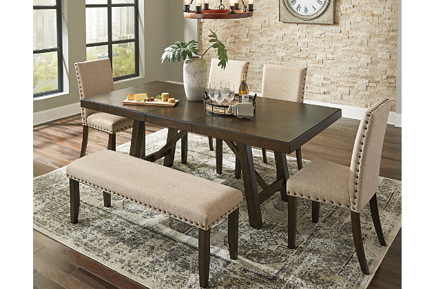 Make gatherings memorable with an ever-trendy farmhouse table. The Rokane dining table keeps things cozy with its rough-sawn plank texturing and warm brown finish. Punctuated with a crossbuck trestle base and extension leaf to accommodate more guests, this urban farmhouse piece is sure to impress come mealtime.Made of solid wood and acacia veneers | Warm brown finish | Seats up to 8 | Separate extension leaf | Table extends by pulling both ends and dropping in the leaf | Assembly required | Estimated Assembly Time: 30 Minutes