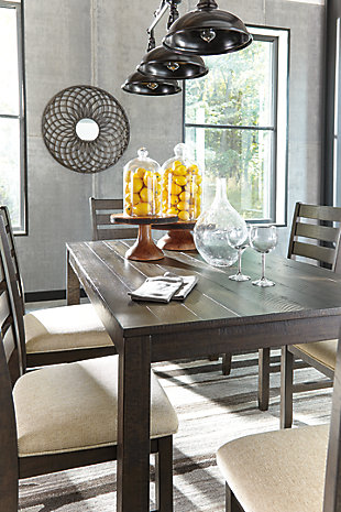You love a clean and contemporary look—so long as it’s warm and inviting. With that in mind, the Rokane dining table set serves your sense of style beautifully. “Rough sawn” style finish with a hint of weathered charm tantalizes with a mood of relaxed elegance. Sumptuously upholstered seats in a neutral, textural fabric make the experience complete.Includes table and 6 upholstered chairs | Table made of veneers, wood and engineered wood | Wood frame chairs | Cushioned seats with textural, polyester upholstery | Estimated Assembly Time: 120 Minutes