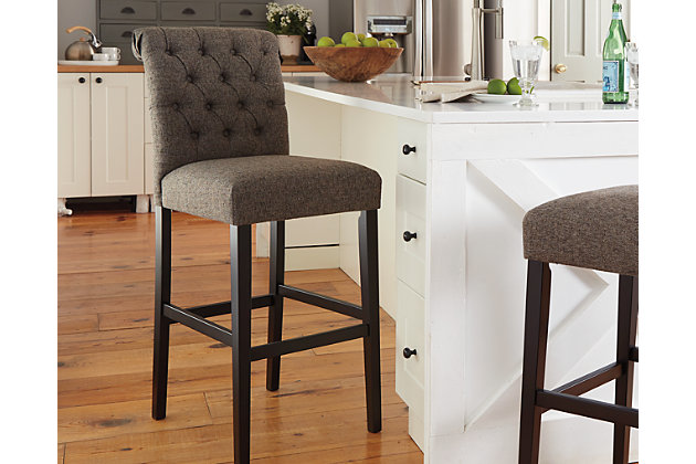 Tripton tall bar stool arrives at the table with full scale comfort. Classic tufting dresses up the beautifully curved back. Both seat and back are firmly cushioned and covered in a graphite textured upholstery.Seat and back covered in polyester, linen-textured upholstery | Wood frame | Assembly required | Estimated Assembly Time: 30 Minutes