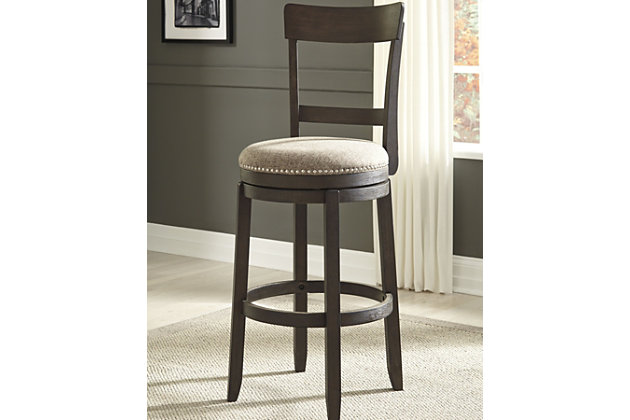 Raise the bar on modern farmhouse style with the Drewing upholstered swivel bar stool. Its clean-lined good looks are accentuated with a comfortably curved backrest and plushly upholstered seat with textural upholstery. Its wire-brushed finish infuses a relaxed, rustic sense of ease.Made of veneers, wood and engineered wood | Distressed, wire-brushed finish | 360-degree swivel | Polyester upholstery over foam cushioned seat | Nailhead trim | Assembly required | Estimated Assembly Time: 30 Minutes