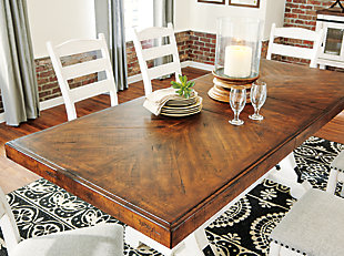 The Valebeck 9-piece dining set serves up the best in rustic farmhouse living. Two-tone distressed finish pairs a brown tabletop with vintage white base for a double helping of charm. Extension dining table features an extra thick edge with book matched inlay veneer. Eight distressed white ladderback chairs upholstered with cushioned seats wrapped in a soothing gray linen colored textural fabric with nailhead trim are something to savor.Includes dining table and 8 chairs | Table made of pine wood, veneer and engineered wood | Table with two-tone finish and black metal accents | Table extends by pulling both ends and dropping in leaf | Table seats up to 8 fully extended | Chairs made of wood | Chairs with distressed vintage white finish | Chairs with cushioned seats in linen colored polyester upholstery | Chairs with nailhead trim | Assembly required | Estimated Assembly Time: 285 Minutes