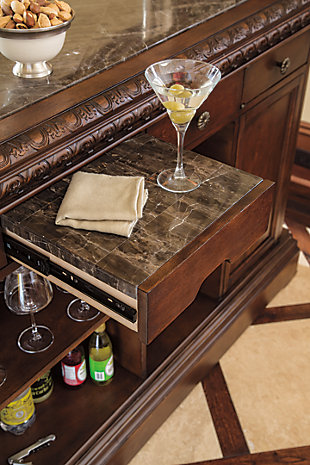 The well-appointed North Shore bar makes for stylish, effortless entertaining. Drinks and appetizers appear more tasteful when presented on beautifully veined marble surface. Multiple drawers and storage areas hold a variety of serving and prepping utensils, stemware and bottles, including a rack dedicated to 12 bottled varieties.Hand-finished | 1 adjustable shelf | Made of veneers, wood, engineered wood, natural marble parquetry and cast resin | 1 pull-out tray with laminate top | Assembly required | 3 drawers | 1 cabinet with 1 adjustable shelf | Antiqued goldtone hardware | 12-bottle wine rack