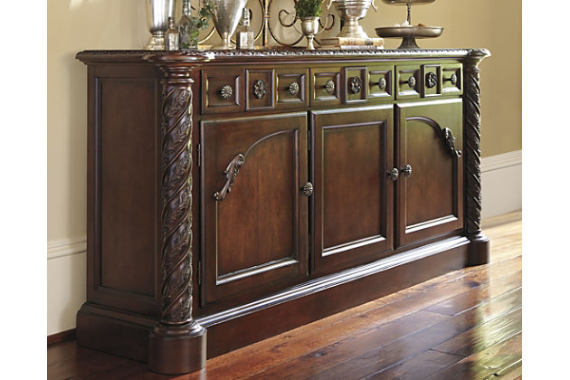 Inspired by the grandeur and grace of Old World traditional style, the North Shore dining room server is nothing short of stunning. A choice blend of materials is accented by the most intricate appliques. And it’s so functional. Four center drawers, two top side drawers and shelved cabinet space behind each door serve your storage needs exceptionally well.Made of veneers, wood, engineered wood and cast resin | Hand-finished | Antiqued goldtone hardware | 3 lined drawers; 1 with silverware liner | 2 cabinets, each with 1 adjustable shelf | Assembly required