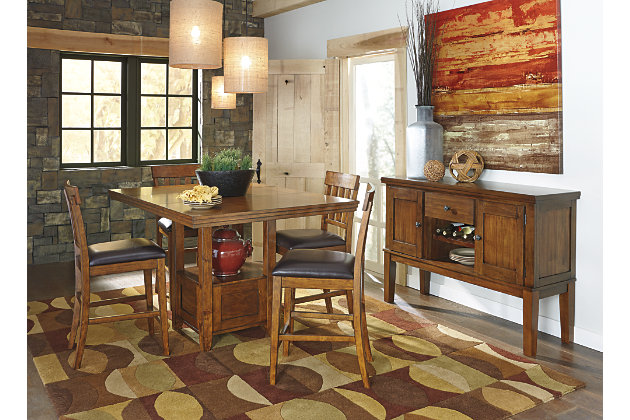 Have an appetite for clean-lined design, but with warmth and rustic character? Satisfaction is served with the Ralene dining room set. Its gently distressed, burnished finish and shelf-style pedestal incorporate depth and character. While the separate extension leaf easily expands your seating options. Bar stools with cushioned faux leather upholstery are a wonderful show of good taste.Includes dining table and 4 upholstered bar stools | Table made of veneers, wood and engineered wood | Bar stools made of wood | Hand-finished | Fixed shelf | Separate extension leaf | Table extends by pulling both ends and dropping in leaf | Assembly required | Seats up to 6 | Estimated Assembly Time: 210 Minutes