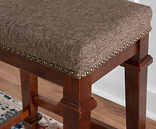 Raise the bar on style with this simply striking upholstered bar stool in walnut finish with brown tweed upholstery. Thickly padded seat covered in easy-clean fabric caters to your comfort level.Made of wood | Walnut finish | Tweed upholstery with foam padding | Nailhead trim | Footrest | Protective glides under legs | Assembly required
