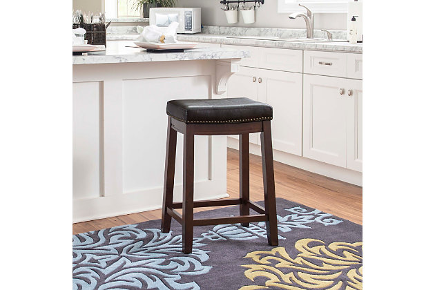 Raise the bar on style with this simply striking upholstered bar stool in dark brown with brown upholstery. Thickly padded seat covered in easy-clean vinyl caters to your comfort level.Made of wood | Dark brown finish | Faux leather upholstery with foam padding | Contoured saddle seat | Nailhead trim | Footrest | Protective glides under legs | Assembly required