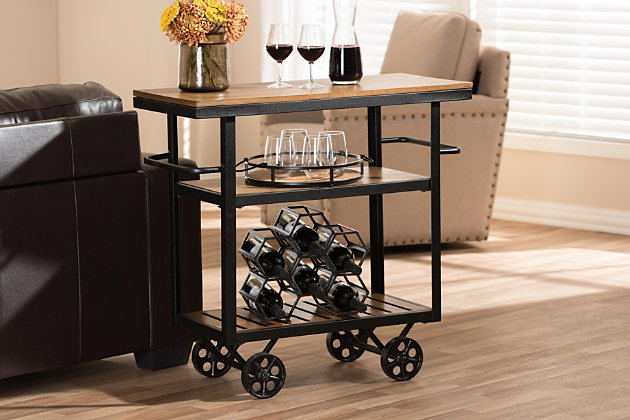 Roll out rustic industrial flair with this ultra-cool kitchen cart. Whether serving as an appliance stand or serving up style in the dining room, this mobile cart with locking casters offers so much versatility. Be it in a modern farmhouse or urban loft, this chic cart with dual towel bars simply says welcome home.Made of engineered wood and tubular metal | Distressed oak-tone finish | Antiqued black hardware | 2 towel bars | 3 levels of storage; slatted bottom shelf | Rolling casters for easy mobility | Assembly required