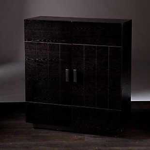 A swanky essential for the entertainer, this bar cabinet in dramatic black with red interior brings back cocktail hour in high style. Behind the double doors, you’ll find nine storage cubbies varying in size to store wine, liquor, glasses and whatever else you want to add to the mix. What a delicious addition to modern or mid-century inspired abodes.Made of engineered wood and veneer | Black finish with dramatic red interior | 2 cabinet doors | 9 storage compartments varying in size | Includes anti-tip hardware for stability | Assembly required | Assembly time frame is 45 to 60 min.