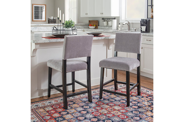 Transitional in style, the Wes Stool has clean lines and a smooth design. The black finished frame is accented by dark gray washed velvet upholstery and embellished with shiny silvertone nailheads. Footrails provide added stability to the sturdy wood frame. Counter height.Made of wood and mdf | Foam cushioned seat | Shiny silvertone nailhead trim | Footrails for stability | Seat height 24" | Black finish | Polyester (velvet) upholstery | Assembly required