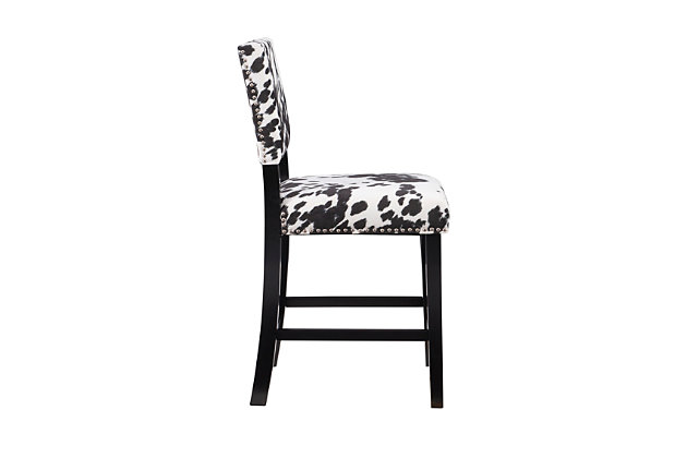 The Wes cow print bar stool has a classic traditional style accented with transitional flair. The stool has a bold cow print plush upholstered seat and back embellished with antique bronze-tone nailhead trim. The straight lined legs are finished in a Manhattan stain. Perfect for a kitchen or dining area. Counter height.Made of wood and mdf | Foam cushioned seat | Black cow print padded upholstery | Shiny silvertone nailhead trim | Footrails for stability | Seat height 24" | Counter height | Assembly required