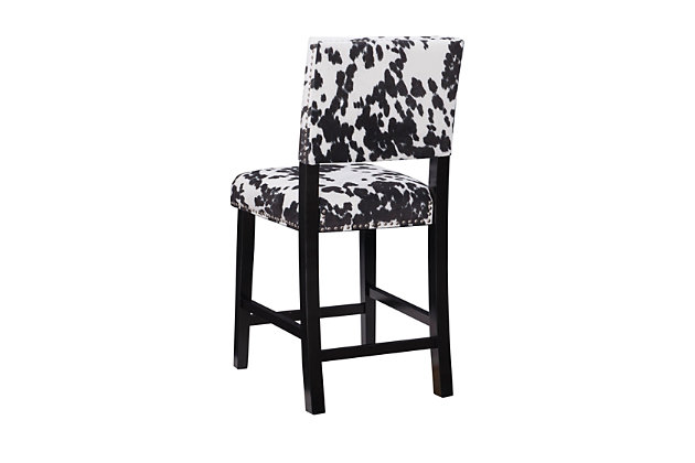 The Wes cow print bar stool has a classic traditional style accented with transitional flair. The stool has a bold cow print plush upholstered seat and back embellished with antique bronze-tone nailhead trim. The straight lined legs are finished in a Manhattan stain. Perfect for a kitchen or dining area. Counter height.Made of wood and mdf | Foam cushioned seat | Black cow print padded upholstery | Shiny silvertone nailhead trim | Footrails for stability | Seat height 24" | Counter height | Assembly required