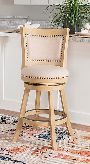 Add rustic style to your kitchen or dining space with the Finn stool. Finished in a neutral gray brown wood, the stool has a padded back and seat. Antique brass-tone nailheads provide that finishing touch. Swivel seat feature enhances its functionality. Crafted from sturdy and durable wood. Counter height.Made of wood and plywood | Foam cushion | Counter stool height | Antique brass-tone nailhead trim | Swivel seat | Sturdy and durable construction | Neutral finish | Assembly required