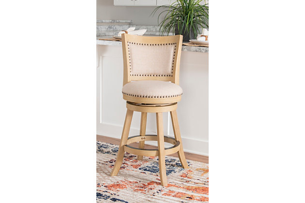 Add rustic style to your kitchen or dining space with the Finn stool. Finished in a neutral gray brown wood, the stool has a padded back and seat. Antique brass-tone nailheads provide that finishing touch. Swivel seat feature enhances its functionality. Crafted from sturdy and durable wood. Counter height.Made of wood and plywood | Foam cushion | Counter stool height | Antique brass-tone nailhead trim | Swivel seat | Sturdy and durable construction | Neutral finish | Assembly required