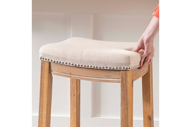The Perry acacia counter stool will add stylish seating to any counter or high top table. The sturdy wood frame has a rustic acacia finish accented by a natural linen upholstered seat. Shiny silvertone nailhead trim makes for an eye-catching detail.Made of acacia wood | Rustic acacia brown finish | Natural linen seat | Shiny silvertone nailhead trim | Counter seat height: 24" | 275 lb. Weight limit | Foam cushion | Assembly required