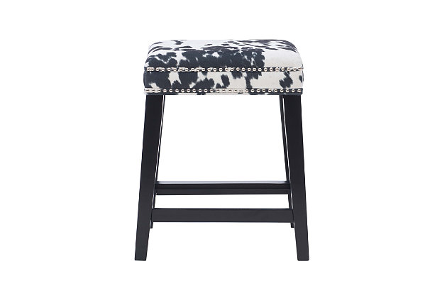 Be moooved by the beauty of Monroe stool. Crafted of sturdy wood in a black finish, this backless stool is accentuated with a bold black cow print wrapping the comfy cushioned seat. Shiny silvertone nailhead trim is a tasteful embellishment. Four footrails provide added stability. Counter height.Made of wood | Counter stool | Foam cushioned seat | Black cow print upholstery | Black finish | Shiny silvertone nailhead trim | Seat height 24.5" | Assembly required