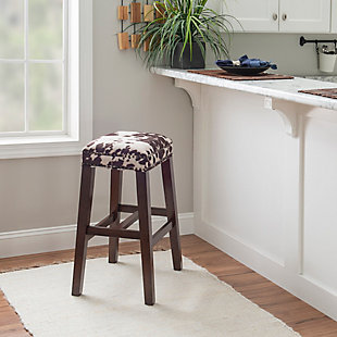 Be moooved by the beauty of Monroe stool. Crafted of sturdy wood in a walnut finish, this backless stool is accentuated with a bold brown cow print wrapping the comfy cushioned seat. Antique brass-tone nailhead trim is a tasteful embellishment. Four footrails provide added stability. Bar height.Made of wood | Bar stool | Backless design | Brown cow print upholstery | Walnut finish | Antique brass-tone nailhead trim | Seat height 30.5" | Assembly required
