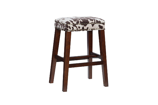 Be moooved by the beauty of Monroe stool. Crafted of sturdy wood in a walnut finish, this backless stool is accentuated with a bold brown cow print wrapping the comfy cushioned seat. Antique brass-tone nailhead trim is a tasteful embellishment. Four footrails provide added stability. Bar height.Made of wood | Bar stool | Backless design | Brown cow print upholstery | Walnut finish | Antique brass-tone nailhead trim | Seat height 30.5" | Assembly required
