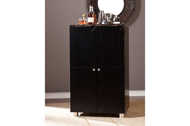 Classy and convenient, this bar cabinet is perfect for entertaining in any size room. The marbleized countertop and painted black finish exude elegance in its space-saving design. This bar cabinet is smartly compact yet amply stores stemware with five hanging racks, and can accommodate up to 20 wine bottles. The large drawer is perfect for wine openers or accessories, and four door shelves feature stainless steel guardrails to securely store bottles and glassware.Made of engineered wood, faux marble, stainless steel and nickel | Marbleized countertop for elegant style | Space-saving design | Accommodates up to 20 wine bottles | Assembly required | Assembly time frame is 45 to 60 min.