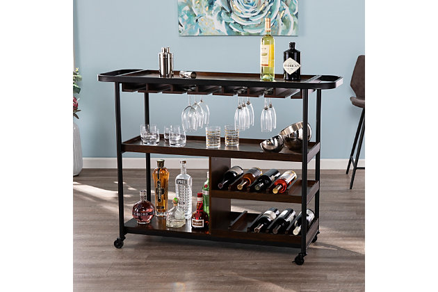 Gather friends and raise your glass with this modern bar cart—perfect for at-home get-togethers. Tray shelving ensures that glasses and utensils stay where they belong, and specially designed storage compartments easily hold wine glasses and bottles. Wheel this wine cart wherever the party may take you, from dining rooms and kitchens to open-concept living spaces.Made of engineered wood and birch veneer Black powdercoat iron frame | 3 shelves with dark tobacco finish | 10 bottle holders | 2 towel rack holders | Stemware rack | Casters for easy mobility | Assembly required | Assembly time frame is 15 to 30 min.