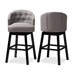Bring happy hour to your home with the elegant Theron bar stool. Constructed from solid rubberwood, it showcases a stunning dark brown finish. The seat and back are upholstered in polyester fabric and padded with foam for endless comfort as you sip cocktails. A built-in footrest provides additional comfort, while button tufting and silver-finished nailheads add a touch of glamour. Equipped with swivel capability, it's well suited for both a kitchen or bar setting. The Theron bar stool is made in Malaysia and requires assembly.Set of 2 | Made of rubberwood in an espresso finish | Polyester fabric upholstery | Swivel capability | Button tufting and silver-finished nailheads | Assembly required