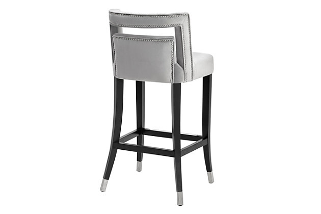 Not for the faint of heart, this stool will make you swoon. Making its debut with a bold statement, the Hart stool is available in bar and counter height options, in your choice of sumptuous grey or navy velvet. Hand-applied nailheads and metal tipped legs match the accompanying footrest.Matching steel footrest | Individually hand-applied silvertone nailheads | Sumptuous velvet upholstery with tufted seat | Birch wood legs with silvertone steel caps | Handmade by skilled furniture craftsmen | Ships assembled