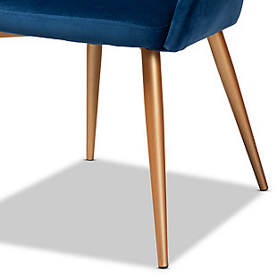 A retro design gets a luxurious update in the Vianne dining chair. Upholstered in a soft, sumptuous navy blue velvet fabric, the Vianne features a curved back and wide seat for the utmost dining comfort. The cut-out back design and splayed gold-tone legs give this chair a glamorous mid-century look.  Use this versatile piece as a dining chair or as an accent chair in the living room. The Vianne dining chair is made in China and requires assembly.Glam and Luxe dining chair | Constructed from metal | Upholstered in velvet polyester fabric and padded with foam | Goldtone finish