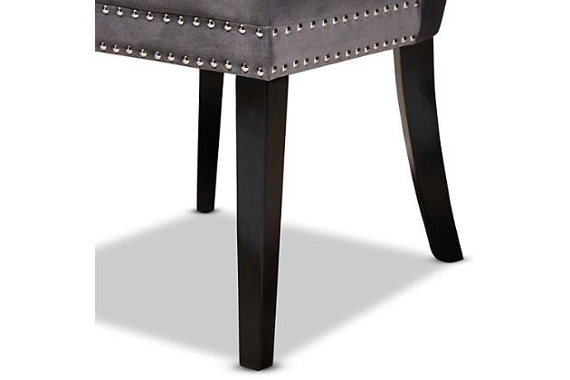 Outfit your dining space with the glamorous Remy dining chair. Set on top of sleek black legs, this oak wood chair is upholstered in a sumptuous velvet fabric that feels exceptionally soft to the touch. Elegant button tufting accentuates the sheen in the velvet, while silver nailheads add a modern touch to the classic silhouette. This versatile chair makes a comfortable seating option in your dining space, as well as a stylish accent piece in your living room or entryway. The Remy dining chair is made in China and requires assembly.Modern and contemporary set includes two (2) dining chairs | Constructed from oak wood and stainless steel | Espresso brown finish | Upholstered in velvet polyester fabric and padded with foam