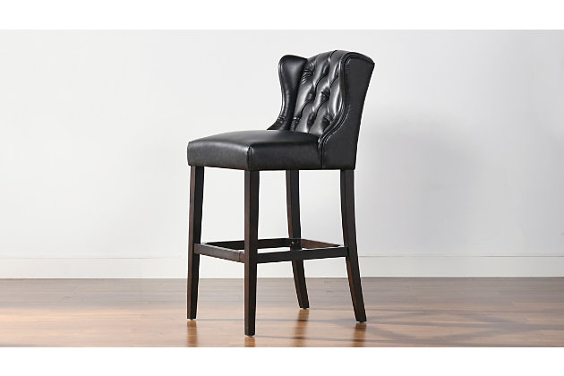 The Richmond Bar Stool Collection by Jennifer Taylor Home fits all your bar stool needs in a classic and comfortable wingback silhouette. The solid birchwood construction in a dark walnut finish pair perfectly with the deep brown faux leather upholstery. Easily wipe away messes from the durable, crack- and peel-resistant fabric, best for the most highly trafficked and mess prone areas of your home such as your kitchen, dining island and dining room. The quality build of each piece begins with a skilled furniture artisan who assembles each piece by hand so you can count on the Richmond bar and counter stools for years to come.Handmade by master furniture craftsmen for the highest level of quality | Sturdy frame of solid wood and sinuous springs provides excellent support and stability | Brass-plated footrest provides comfortable seating and resists scuffs and scratches | Upholstered in peel and crack resistant faux leather for easy cleaning and durability | Hand pulled button tufting and wingback silhouette for style, comfort, and support | Available in 30" and 26" seat heights for bars and counters