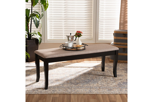 Add casual elegance to your dining room set up with the Cornelie dining bench. This bench is constructed from sturdy wood, with its sleek dark brown finish complementing the soft, sand fabric upholstery. An optimal balance of comfort and style, this bench features a plush foam-padded seat, as well as classic cabriole legs that enable ample leg room. The Cornelie dining bench is well suited for both casual and formal dining.Made of oak wood and rubberwood | Dark brown finish | Upholstered in polyester fabric and padded with foam | Cabriole legs | Assembly required