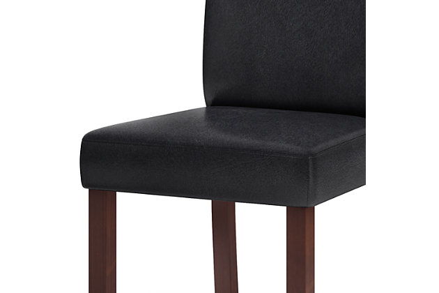 The Acadian parson chair is a tasteful, well-made seating solution. The dining chair is made from durable fabrics and showcases a beautiful stitched exterior. Contemporary in design, this piece will bring chic style to your dining room.Set of 2 | Made with wood and engineered wood | High-density foam seat with webbing suspension | Distressed black polyurethane (faux leather) upholstery | Assembly required