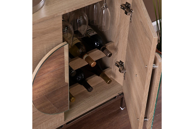 Keep your favorite drinks close at hand with this modern bar cabinet. Two shelves organize spare glassware and bar essentials, while double doors tuck away necessities for a clean, clutter-free space. Mirrored hardware brings a contemporary feel, adding style and dimension to your dining area or living room. Entertain like a pro when you station this wine cabinet with storage alongside your dining table or in your open concept space.Modern wine cabinet | Features 2 cabinets w/ 2 shelves | Includes 6 bottle holders and 3 glassware racks | Holds up to 9 wine glasses | Mirrored door handles add contemporary flair