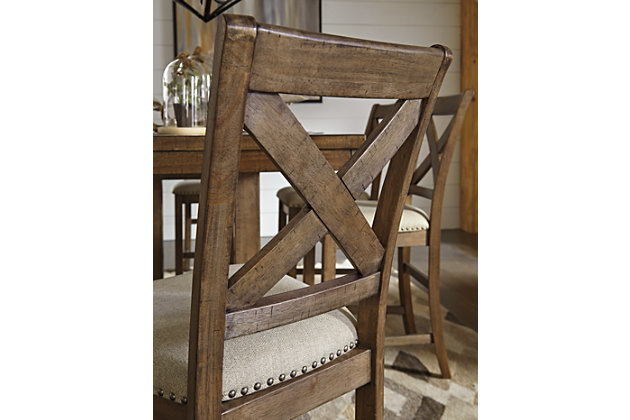 The Moriville upholstered bar stool might be simple at first sight, but a closer look reveals beauty in the details. With a distressed nutmeg finish, antiqued nailhead trim and textured polyester upholstery, it’s beaming with charm. Cushioned seat ensures long, lingering meals are enjoyed in comfort.Made of wood | Polyester upholstery | Nailhead trim with antiqued bronze-tone finish | Assembly required | Excluded from promotional discounts and coupons | Estimated Assembly Time: 45 Minutes