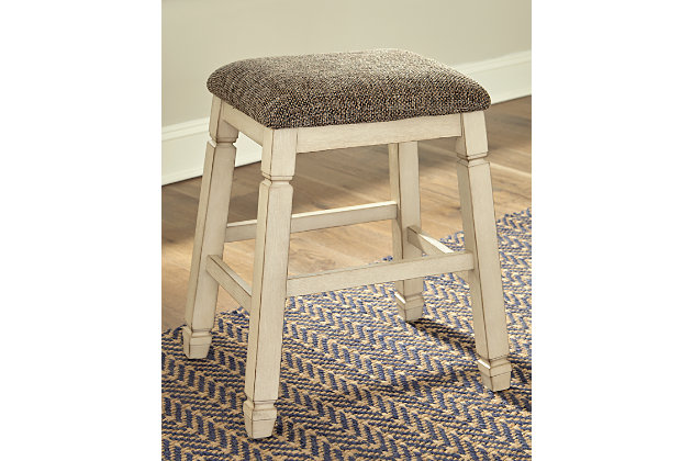 The beauty of the Bolanburg upholstered bar stool is something to savor. Designed to serve up comfort and flair, this backless bar stool entices with a saddle seat covered in a heavy woven fabric that complements the antiqued white finish.Made of solid wood | Antiqued white finish | Cushioned seat upholstered in heavy woven polyester fabric | Assembly required | Estimated Assembly Time: 30 Minutes