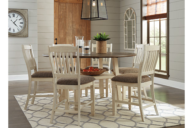 Whether your style is farmhouse fresh, shabby chic or country cottage, you'll find the Bolanburg drop leaf counter height dining table set works on so many levels. The two-tone, gently distressed detailing and plank-effect top on the table accentuates the textured antique white on the bar stool chairs—for double the character, and the appeal. Since all four sides of the table fold, you can go from a round table that seats six, to a compact square design in no time. Built-in display shelf punctuates the set with form and function.Includes drop leaf counter dining table and 6 bar stools | Table made of veneers, wood and engineered wood | Bar stools made of solid wood with heavily woven fabric upholstered seats | Fixed shelf and plank-style top on table | Table with 4 hinged drop leaves | Seats up to 6 | Assembly required | Estimated Assembly Time: 120 Minutes