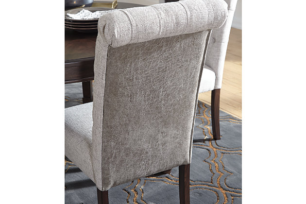 You love the look of traditional furniture—as long as it’s not overly formal. Behold the best of both worlds in the Adinton upholstered dining room chair. The combination of classic and up-to-date design proves that opposites really do attract. Sleek lines and a rich finish showcase its craftsmanship, while sumptuous cushioning and button-tufted upholstery attest to its comfort. With these fine details, you can dress up a room, yet keep it feeling casual for today's lifestyle.Made of wood | Warm brown finish | Soft woven polyester linen hued upholstery | Cushioned seats | Curved, button-tufted backs | Estimated Assembly Time: 30 Minutes
