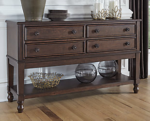 You love the look of traditional furniture—as long as it’s not overly formal. Behold the best of both worlds in the Adinton dining room server. The combination of classic and up-to-date design proves that opposites really do attract. Sleek lines and a rich finish showcase its craftsmanship, while starburst veneer with a cross banded border attest to its style. Proving that it’s practical as well as pretty, four smooth-gliding drawers and an expansive open shelf keep it feeling casual for today's lifestyle.Made of wood, birch veneers and engineered wood | Warm brown finish | 4 smooth-gliding drawers with dovetail construction | Antiqued brass-tone hardware | Fixed lower shelf | Assembly required | Estimated Assembly Time: 30 Minutes