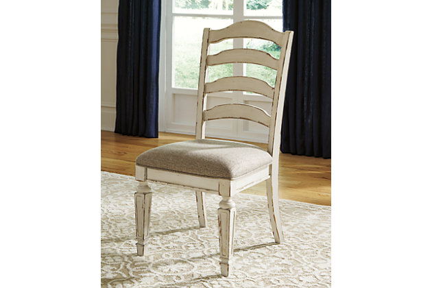 Bon appétit. With its rounded ladderback styling, chipped white finish and plushly cushioned seat, the Realyn dining room chair has all the right ingredients for a French country-inspired feast for the eyes.Made with wood and engineered wood | Distressed, chipped white finish | Ladderback styling | Polyester upholstery over foam cushioned seat | Assembly required | Estimated Assembly Time: 30 Minutes