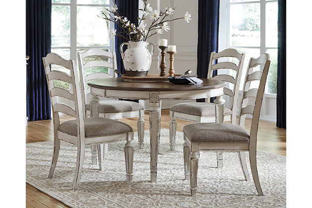 Bon appétit. The Realyn 5-piece dining room set has all the right ingredients for a French country-inspired feast for the eyes. Drop-in leaf allows you to transform the intimate round dining table into a gracious oval table that comfortably seats six. Antiqued two-tone aesthetic pairs chipped white with a distressed wood finished top for a double serving of charm. With its rounded ladderback styling and plushly cushioned seat, this dining room chair is sure to entice you to linger a little longer.Includes dining table and 4 chairs | Assembly required | Table made of veneer, wood and engineered wood | Antiqued two-tone finish | Separate extension leaf | Table extends by pulling both ends and dropping in leaf | Table seats up to 6 | Chair made with wood and engineered wood | Distressed, chipped white finish | Ladderback styling | Polyester upholstery over foam cushioned seat | Estimated Assembly Time: 135 Minutes