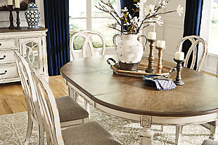 Bon appétit. The Realyn dining room extension table has all the right ingredients for a French country-inspired feast for the eyes. Drop-in leaf allows you to transform an intimate round dining table into a gracious oval dining table that comfortably seats six. Antiqued two-tone aesthetic pairs a chipped white with a distressed wood finished top for a double serving of charm.Made of veneers, wood and engineered wood | Antiqued two-tone finish | Separate extension leaf | Table extends by pulling both ends and dropping in leaf | Seats up to 6 | Dining chairs sold separately | Assembly required | Estimated Assembly Time: 15 Minutes