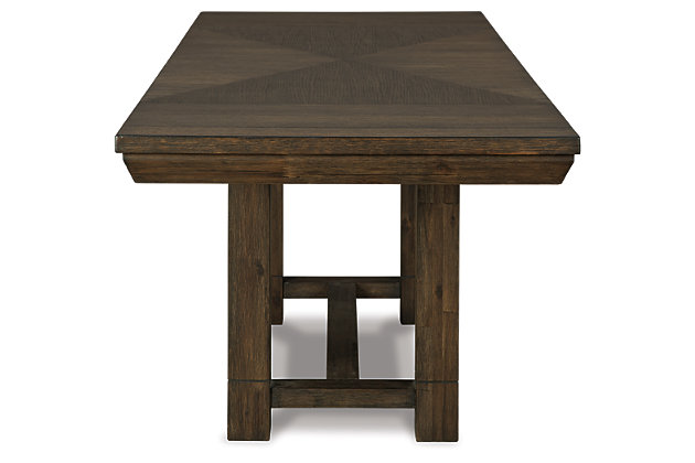 Feast your eyes on the Dellbeck dining table. Its inlaid veneer tabletop supported by a four-post trestle base is a look worth lingering over. When unexpected guests drop by, two extension leaves make entertaining a breeze.Made of wood, veneers and engineered wood | Dark brown finish | 2 removable extension leaves | Seats up to 8 | Assembly required | Dining chairs sold separately | Estimated Assembly Time: 30 Minutes