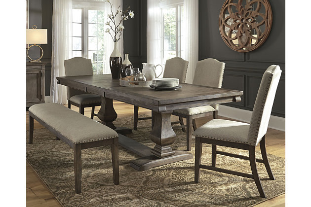 Homey. Hearty. Heavenly hued. Luring with a distressed weathered gray finish, double pedestal base with great presence and sumptuous upholstery for a touch of luxury, the Johnelle 6-piece dining room extension table set is made to make your homestead feel that much more like home. A richly crafted masterpiece, the handsome extension table with thick drop-in leaf is sure to serve up years of satisfaction. Fresh and neutral linen-weave upholstered bench and four upholstered chairs with classic camelback flair are an inspired accompaniment. Includes adjustable, high-quality levelers attached to the two front chair legs to ensure stability on uneven surfaces. Use them to eliminate wobble and give your family and guests a comfortable, stable and relaxing dining experience.Includes dining room extension table, upholstered bench and 4 upholstered dining chairs | Table made of veneers, pine and acacia wood and engineered wood | Distressed weathered gray finish | Separate extension leaf | Table extends by pulling both ends and dropping in leaf | Seats up to 8 | Chairs and bench made of solid wood | Polyester upholstery over foam cushioned seat, with contrasting nailhead trim | Includes high quality adjustable leveler feet attached to the two front legs of each chair | Assembly required | Estimated Assembly Time: 170 Minutes