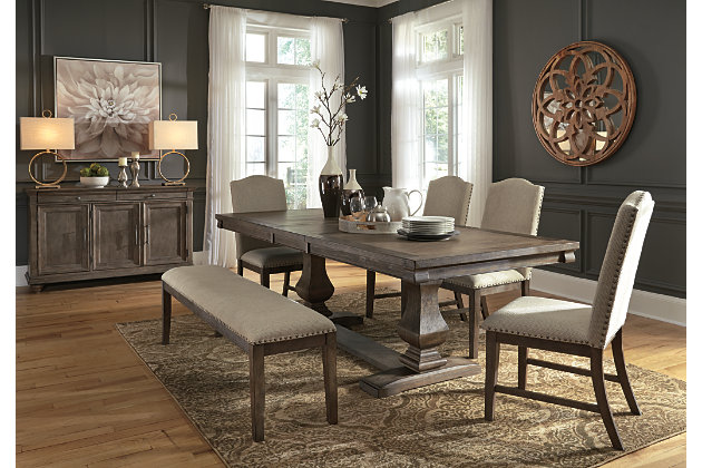 Alluring in a distressed weathered gray finish, the Johnelle 7-piece dining set makes your homestead feel that much more like home. A richly crafted masterpiece, this handsome extension table with thick drop-in leaf has a double pedestal base with square baluster legs and is sure to serve up years of satisfaction. The dining server includes lined drawers and adjustable shelving has the capacity to put your plates, silverware, linens and serving essentials well within reach. Fresh and neutral linen-weave upholstery on the chairs and bench is punctuated with contrasting nailhead trim for added character.Includes extension dining table, dining server, 4 dining side chairs and bench | Table made of veneers, pine and acacia wood and engineered wood | Server made of elm veneers, solid wood and engineered wood with dark gray pewter-tone hardware | Distressed weathered gray finish | Table includes extension leaf and extends by pulling both ends and dropping in leaf | Table seats up to 8 | Server with 2 felt-lined silverware drawers, 3 cabinet doors and 3 adjustable shelves | Chairs and bench made of solid wood | Polyester upholstery over foam cushioned seat | Contrasting nailhead trim | Assembly required | Estimated Assembly Time: 185 Minutes