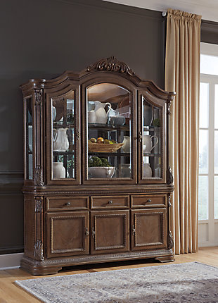 The Charmond dining room buffet’s uniquely luxurious interpretation of traditional style says it all. Exquisitely detailed with scrolled acanthus accents and treated to a multi-hued finish, it’s clearly a labor of love. Three cabinets and an expansive surface serve your entertaining needs exceptionally well.Made of veneers, wood, engineered wood and cast resin | Dark brown finish with glazed white highlights | Antiqued goldtone hardware | 3 lined drawers with black felt bottom | 1 large double cabinet and 1 smaller single cabinet, each with 1 adjustable shelf | Estimated Assembly Time: 15 Minutes