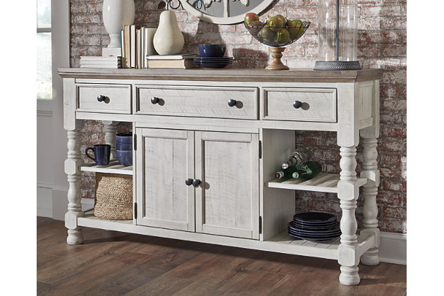 Have your fill of modern farmhouse style with the Havalance dining room server. Distressed two-tone treatment blends a weathered gray with vintage white for an utterly charming effect. Robust posts and thick mouldings lend a hearty, substantial look that feels right at home. Along with drawer and cabinet storage, reversible wine rack/shelves add to its toast-worthy appeal.Made of pine wood, pine veneer and engineered wood | Two-tone distressed finish: weathered gray top; vintage white base | 2 reversible wine rack/shelves | 3 smooth-gliding drawers (with felt lining) | Double-door cabinet with single-shelf storage | Aged iron-color knobs | Assembly required | Estimated Assembly Time: 60 Minutes
