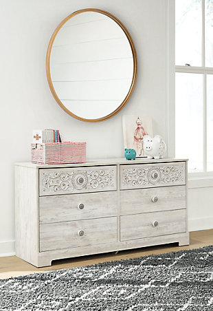 If it’s coastal chic or cottage quaint style you long for, the Paxberry whitewashed dresser invites you to go to town. Its distinctive weatherworn finish conveys an easy-breezy sensibility, perfect for a restful bedroom retreat. Tastefully edited lines and medallion drawer pulls give this attractively priced dresser a high-end aesthetic.Dresser only | Made of engineered wood and decorative laminate | Whitewash replicated worn through paint with authentic touch | Hardware features a worn-through painted effect | 6 spacious smooth-gliding drawers; vinyl wrapped sides and back for extra durability | Safety is a top priority, clothing storage units are designed to meet the most current standard for stability, ASTM F 2057 (ASTM International) | Drawers extend out to accommodate maximum access to drawer interior while maintaining safety | Assembly required | Estimated Assembly Time: 50 Minutes