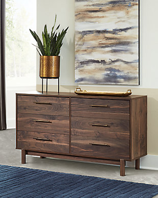 At the intersection of industrial cool and chic sophistication you’ll find the Calverson dresser. The rich brown finish over replicated walnut wood grain and burnished goldtone handles offer an authentic touch that plays well any way you style it. Simple and elegant in its design, this piece keeps your home decor grounded while elevating your modern style.Made of engineered wood and decorative laminate | Rich brown finish over replicated walnut wood grain with authentic touch | Burnished goldtone pulls | 6 smooth-gliding drawers | Vinyl wrapped drawer sides and back for extra durability | Safety is a top priority, clothing storage units are designed to meet the most current standard for stability, ASTM F 2057 (ASTM International) | Drawers extend out to accommodate maximum access to drawer interior while maintaining safety | Assembly required | Estimated Assembly Time: 55 Minutes